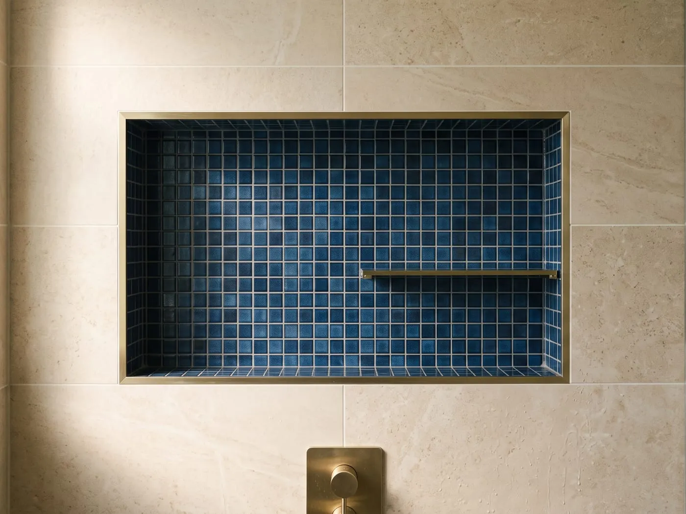 Beleuchtete Duschnische mit blauem Mosaik und goldener Armatur