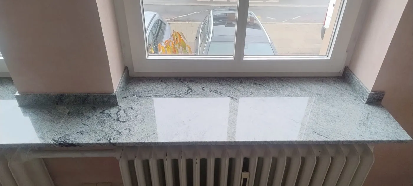 Granit-Fensterbank am Wandanschluss: die Bank läuft mit passend eingefasstem Sockel um die Ecke